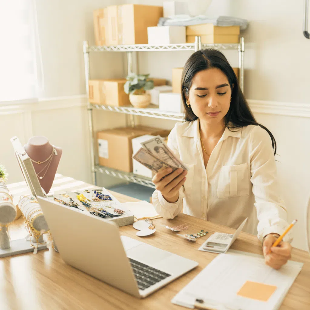 Mujer revisando cuentas con dinero y joyas