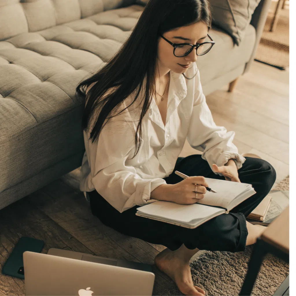 Mujer escribiendo en un cuaderno en casa.