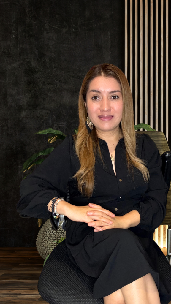 Mujer sentada con fondo oscuro y plantas
